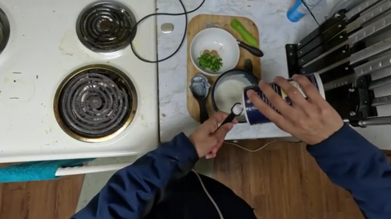 A person about to add too much salt to a bowl, illustrating a moment requiring intervention.